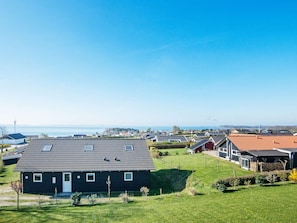 A residential area with houses, a grassy lawn, and a clear sky. - 10 Person Holiday Home in Ronde (Ronde)