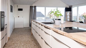 A modern kitchen with a large island, built-in appliances, and a view through the windows. - 10 Person Holiday Home in Ronde (Ronde)