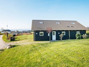 A two-story house with a tiled roof, a front door, and a small garden. - 10 Person Holiday Home in Ronde (Ronde)