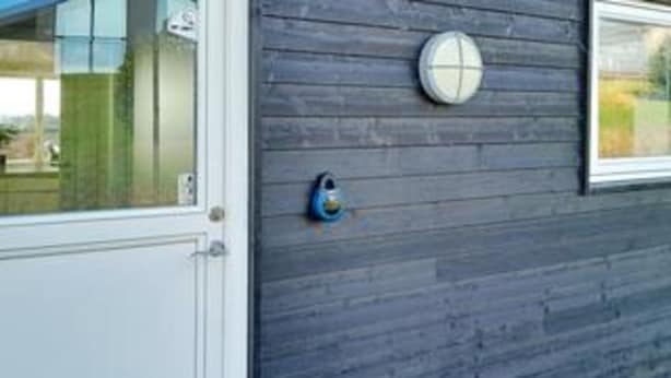 A door with a glass panel and a round, blue security device on the wall. - 10 Person Holiday Home in Ronde (Ronde)