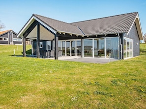 A modern house with a covered patio, large glass windows, and a sloped roof. - 10 Person Holiday Home in Ronde (Ronde)