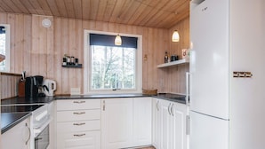A kitchen with white cabinets, a window, and a refrigerator. - 7 Person Holiday Home in Ulfborg (Ulfborg)