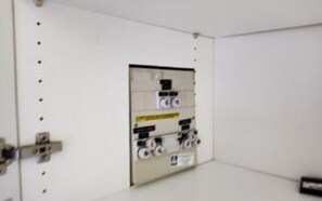 A white room with a door and a panel with electrical outlets and switches. - 7 Person Holiday Home in Ulfborg (Ulfborg)
