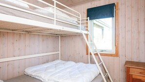 A bunk bed room with a window, wooden walls, and a small wooden cabinet. - 7 Person Holiday Home in Ulfborg (Ulfborg)
