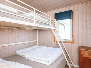A bunk bed room with a window, wooden walls, and a small wooden cabinet. - 7 Person Holiday Home in Ulfborg (Ulfborg)