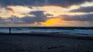 A beach with waves and a sunset. - 7 Person Holiday Home in Ulfborg (Ulfborg)
