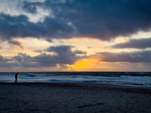 A beach with waves and a sunset. - 7 Person Holiday Home in Ulfborg (Ulfborg)