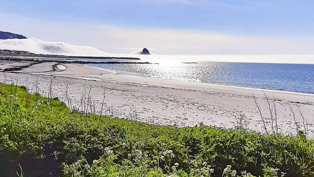 A beach with a clear sky, calm sea, and a distant mountain. - 4 Star Holiday Home in Sortland (Sortland)