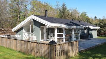 A two-story house with a covered porch and a fenced yard.