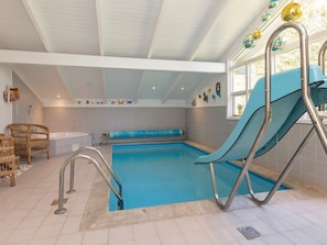 An indoor swimming pool with a slide, a bathtub, and a seating area with chairs. - 8 Person Holiday Home in Hals (Hals)