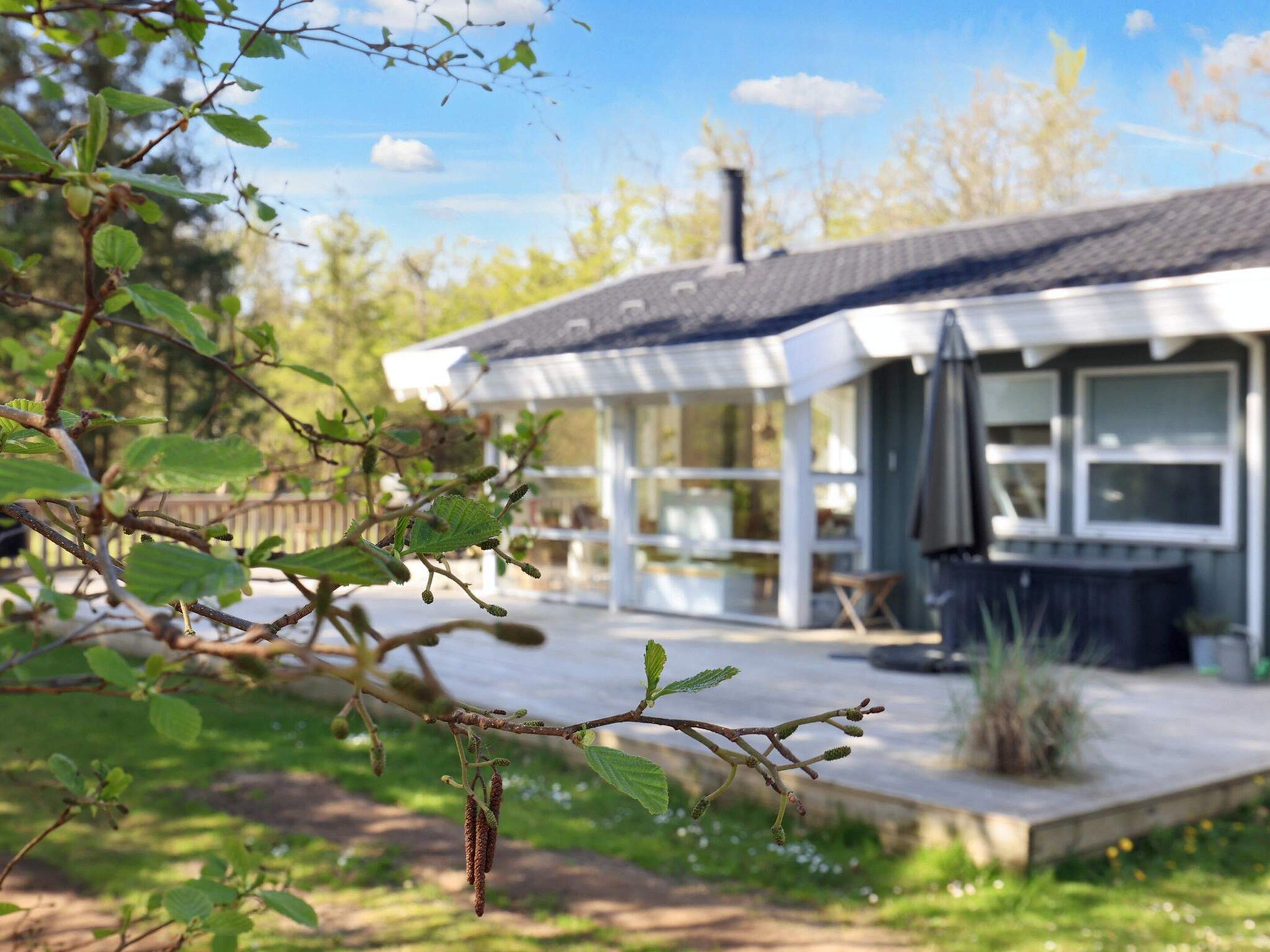 A house with a covered porch, a deck, and a view of a body of water.