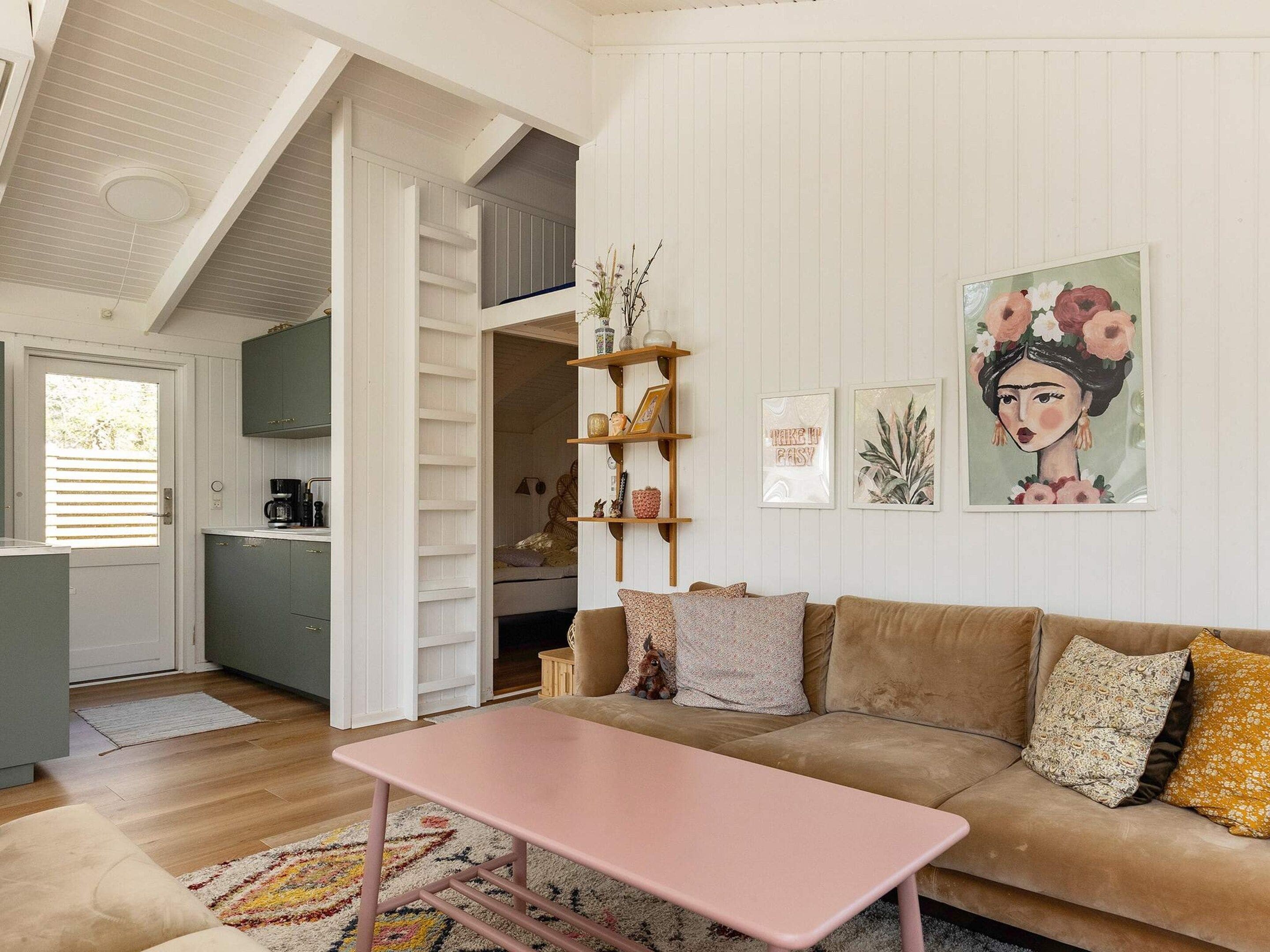 A cozy living room with a sofa, a coffee table, and a bookshelf.