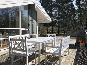 A deck with white furniture, including a table and chairs, and a grill. - 8 Person Holiday Home in Hals (Hals)