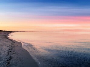 A beach with a calm sea and a clear sky.