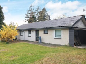 A single-story house with a grey roof and a small front yard.