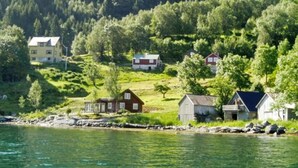 A coastal village with houses by the water, surrounded by greenery and hills. - 11 Person Holiday Home in Davik-by Traum (Bremanger)