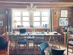 A cozy room with a wooden interior, a dining table with chairs, a laptop, and various decorative items. - 11 Person Holiday Home in Davik-by Traum (Bremanger)