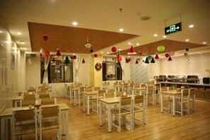 A dining area with multiple tables and chairs, a counter, and a ceiling with wooden slats and recessed lighting. - Sanyuesan Theme Hotel (Liannan)