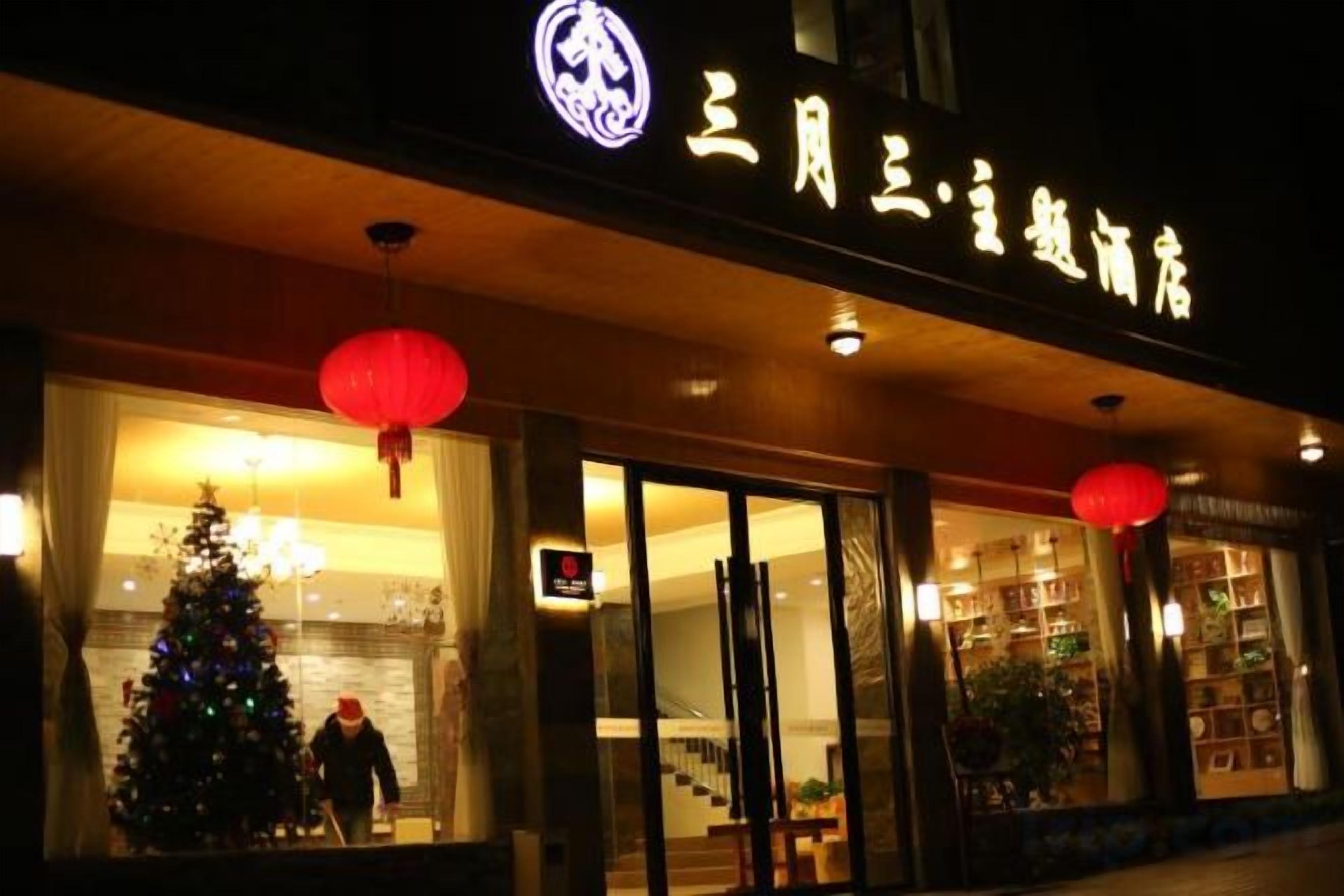 A hotel entrance with a Christmas tree and red lanterns.