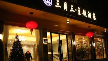 A hotel entrance with a Christmas tree and red lanterns.