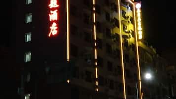 A multi-story building with illuminated signage, likely a hotel or commercial property.