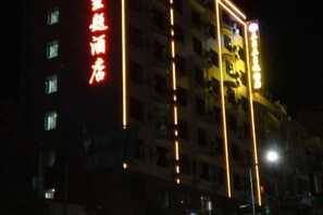 A multi-story building with illuminated signage, likely a hotel or commercial property. - Sanyuesan Theme Hotel (Liannan)