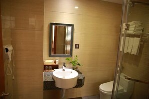 Un baño con lavamanos, espejo e inodoro.