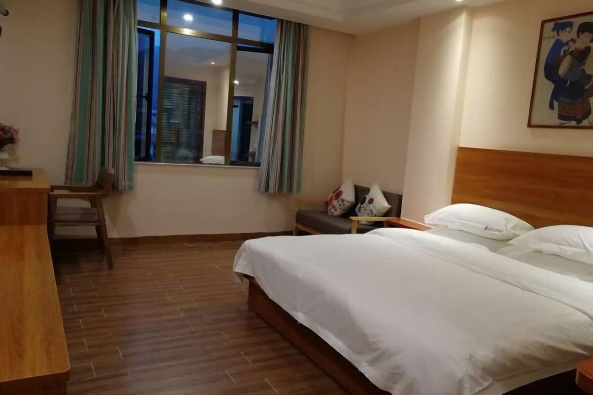 Una habitación de hotel con una cama, un escritorio y una silla.