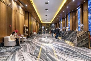 A hotel lobby with marble flooring, seating areas, and a reception desk. - Sunny Hotel (Taizhou)