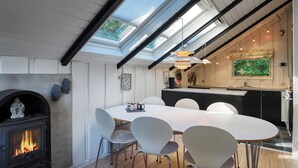 A modern kitchen with a large island, skylights, and a stone fireplace. - 6 Person Holiday Home in Vaeggerlose (Vaeggerlose)