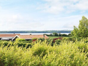 A residential area with houses, a lake, and a forested landscape.
