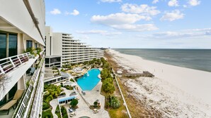 A hotel with a pool, beach, and ocean view.