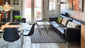 A modern living room with a sofa, chairs, a coffee table, and a dining area. - 6 Person Holiday Home in Hadsund (Hadsund)