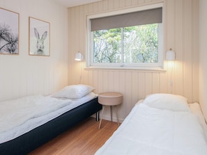 A bedroom with two beds, a window, and two wall-mounted lamps. - 5 Star Holiday Home in Blavand (Blavand)