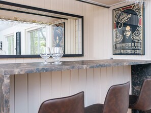 Eine Bar mit einer Marmorplatte, zwei Weingläsern und einem Poster von Nina Simone.