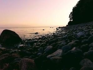 A rocky shoreline with a calm sea and a distant horizon. - 4 Star Holiday Home in Borre (Borre)