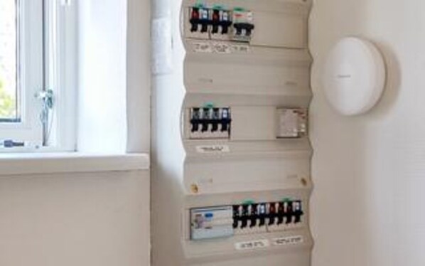 Un tableau électrique fixé au mur, doté de plusieurs disjoncteurs.
