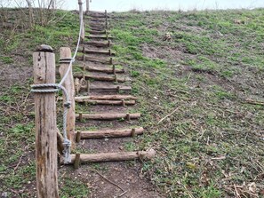 A wooden staircase with a rope handrail, leading up a grassy hill. - 4 Star Holiday Home in Borre (Borre)