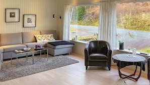 A modern living room with a sofa, armchair, coffee table, and a rug. - 8 Person Holiday Home in Halsanaustan-by Traum (Heim)