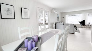 A modern dining area with a white table, grey chairs, and a tray with candles. - 8 Person Holiday Home in Halsanaustan-by Traum (Heim)