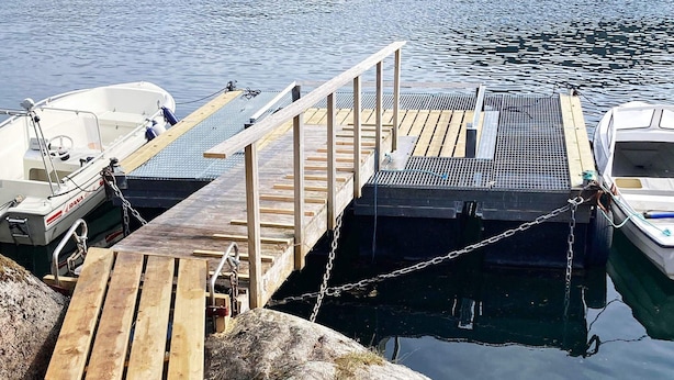 A wooden dock with a metal railing, connected to a boat docked on the water. - 8 Person Holiday Home in Halsanaustan-by Traum (Heim)