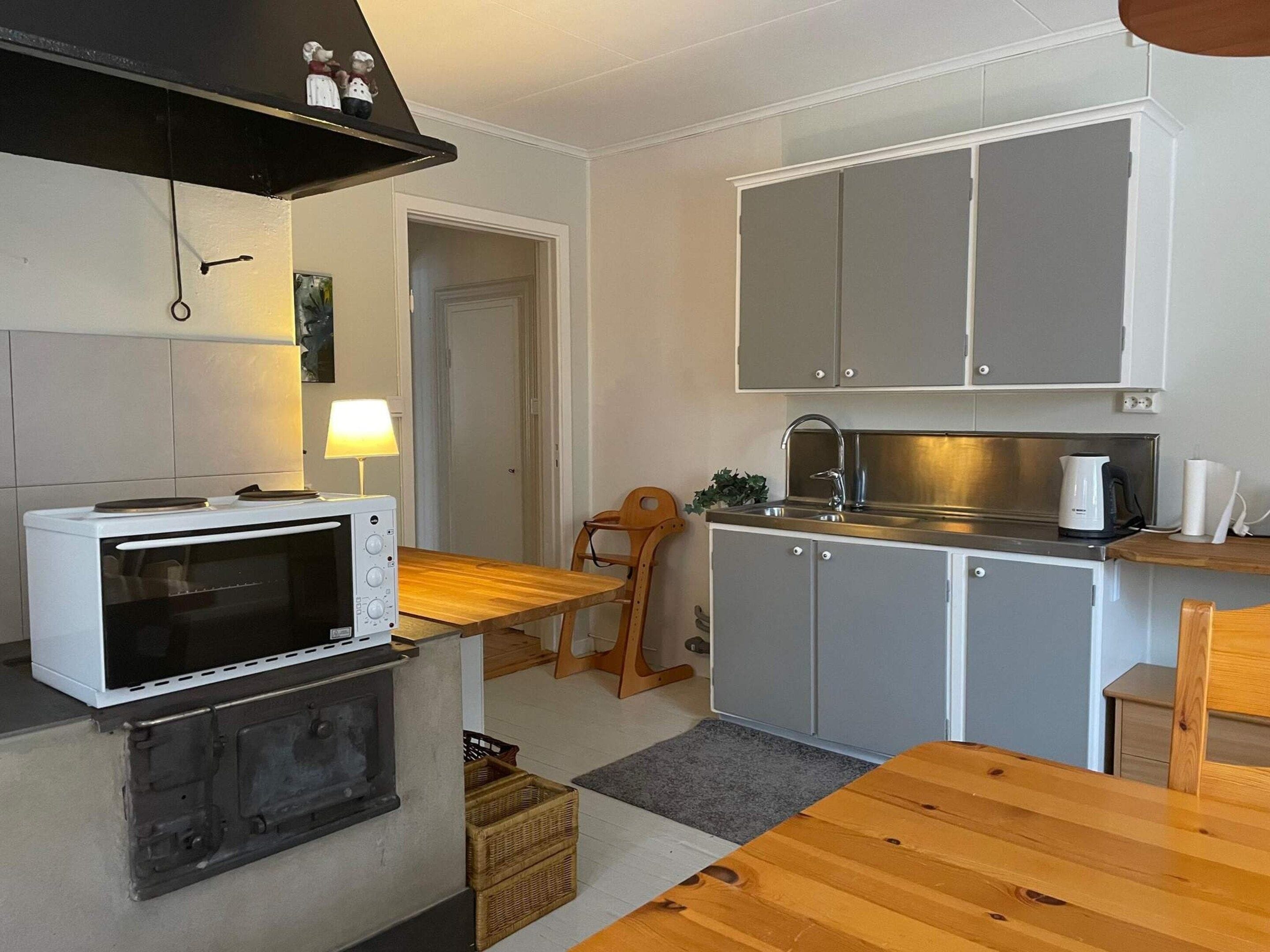 A compact kitchen with a microwave, stove, and cabinets.