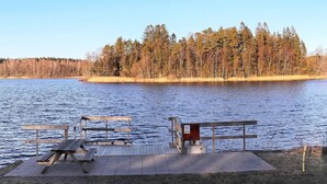 A lakeside view with a wooden dock, picnic table, and benches. - 4 Star Holiday Home in Ullared (Ullared)