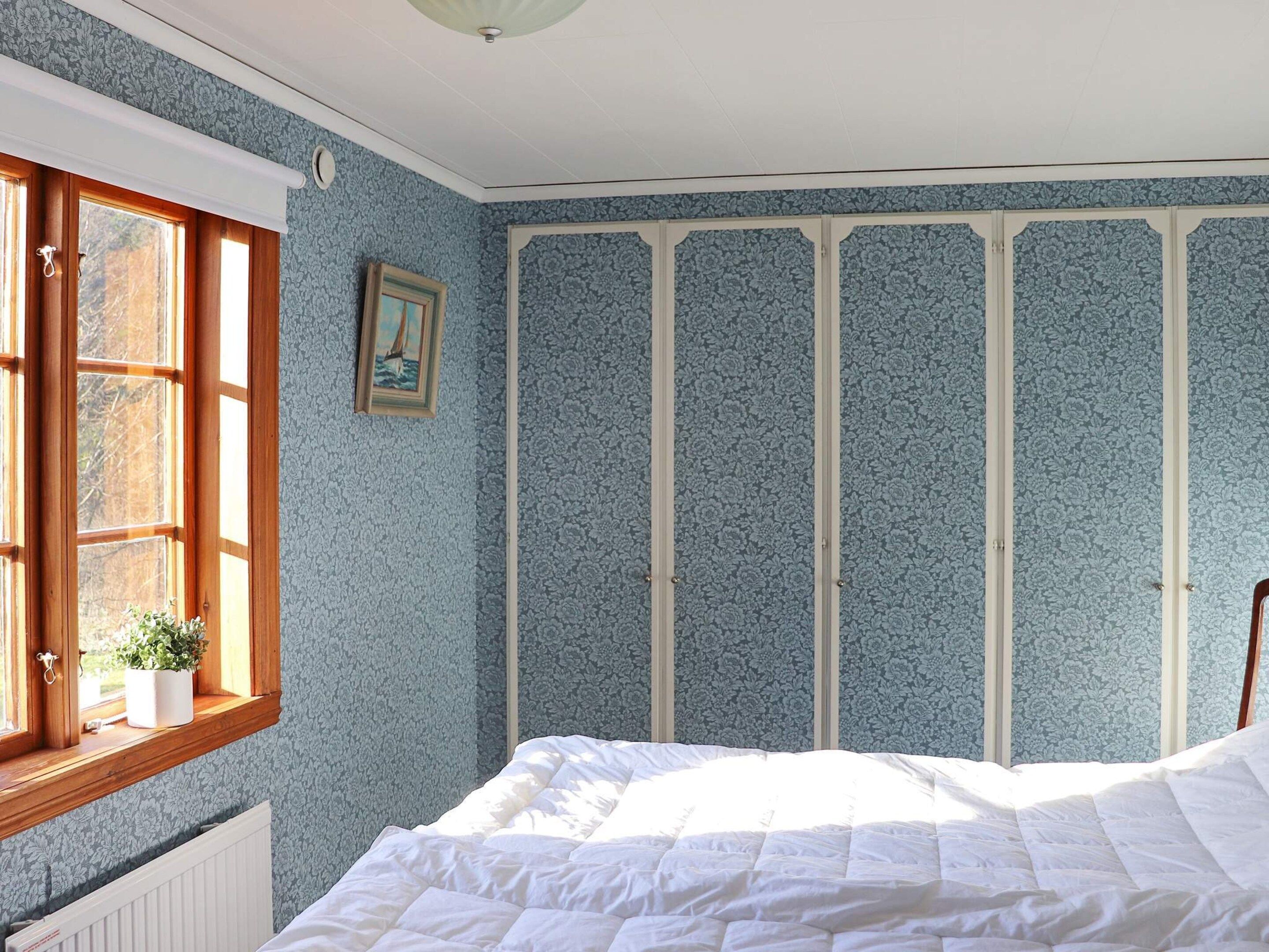 A bedroom with a bed, a window with a view, and a radiator.