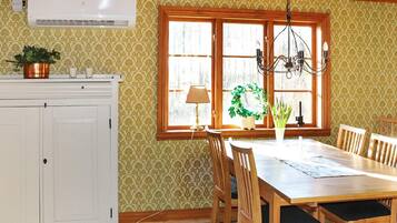 Un comedor con mesa y sillas de madera, un candelabro y una ventana con vistas.