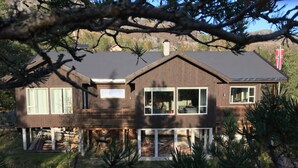 A two-story wooden house with a deck, large windows, and a flag. - 4 Star Holiday Home in Skare (Ullensvang)