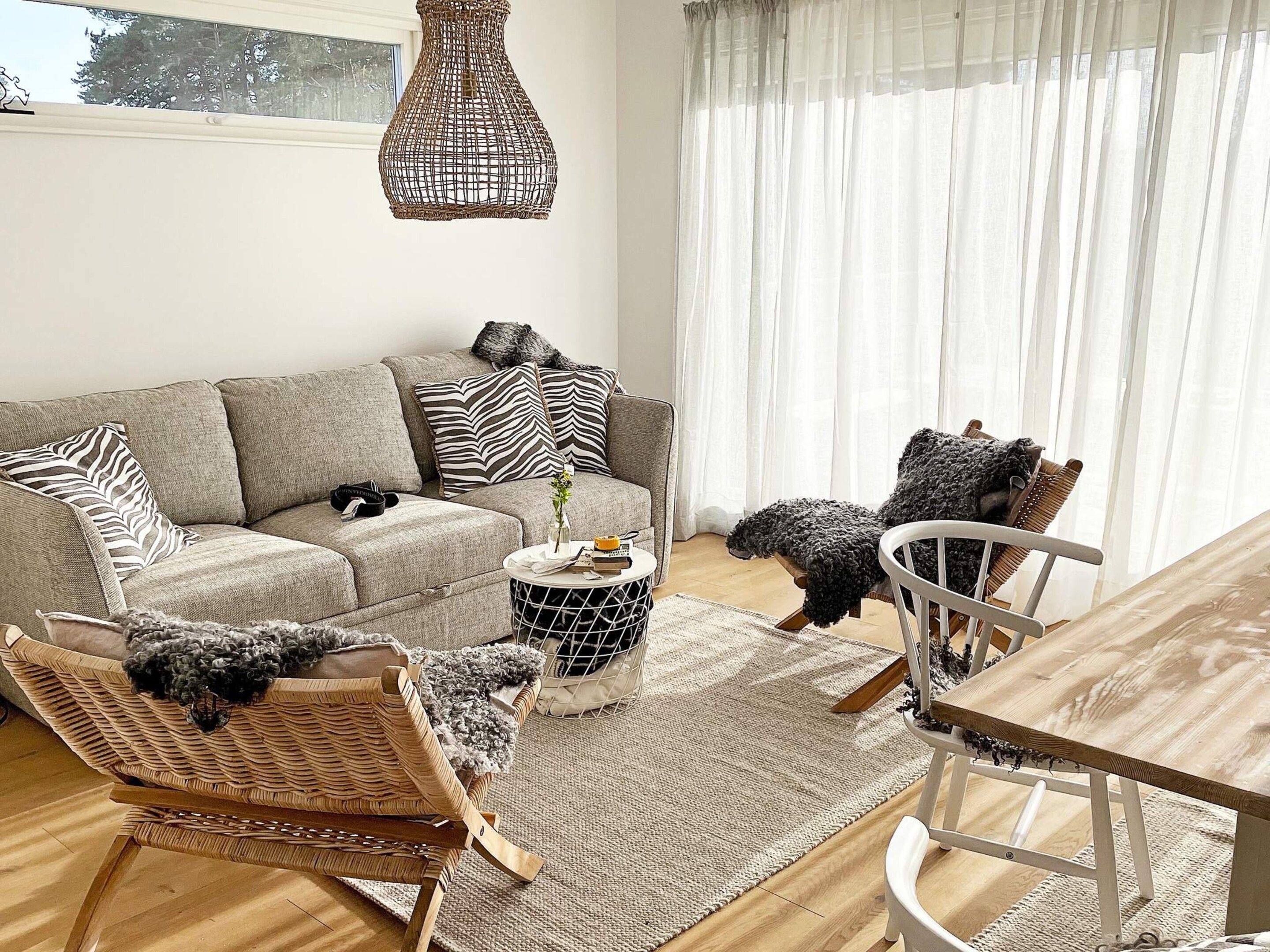 Un salon comprenant un canapé, des fauteuils, une table basse et une table à manger.