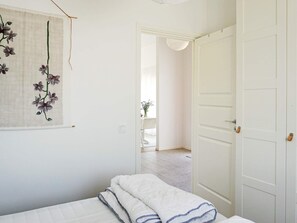 Un dormitorio con una cama, una puerta y vistas a otra habitación.