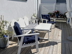 A deck with white furniture, including a sofa and chairs, and potted plants. - 4 Star Holiday Home in Gotlands Tofta (Gotlands Tofta)