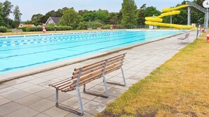 A swimming pool with a wooden bench and a yellow water slide. - 6 Person Holiday Home in Solvesborg-by Traum (Sölvesborg)